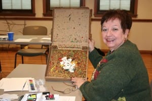 An auxiliary volunteer at the Armes Family Cancer Care Center shows her creation. The leaf was painted using a process that included acrylic paints and rolling marbles inside a pizza box to create the design.