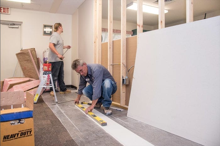 construction worker hard at work hanging drywall