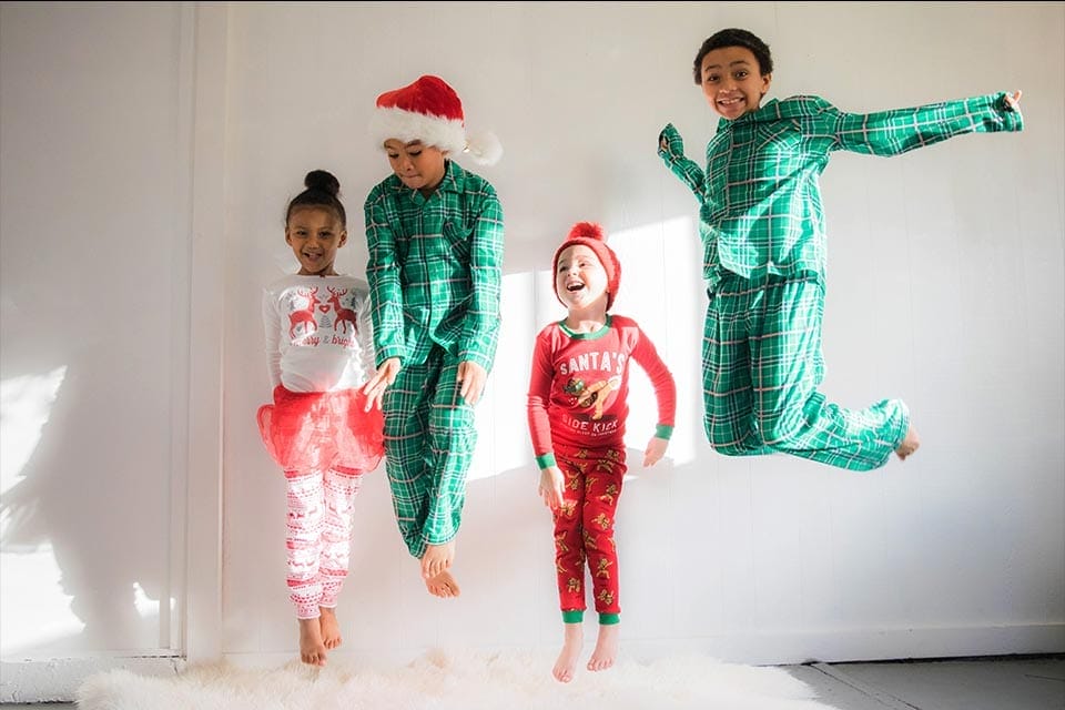 Kids jumping in Christmas pajamas