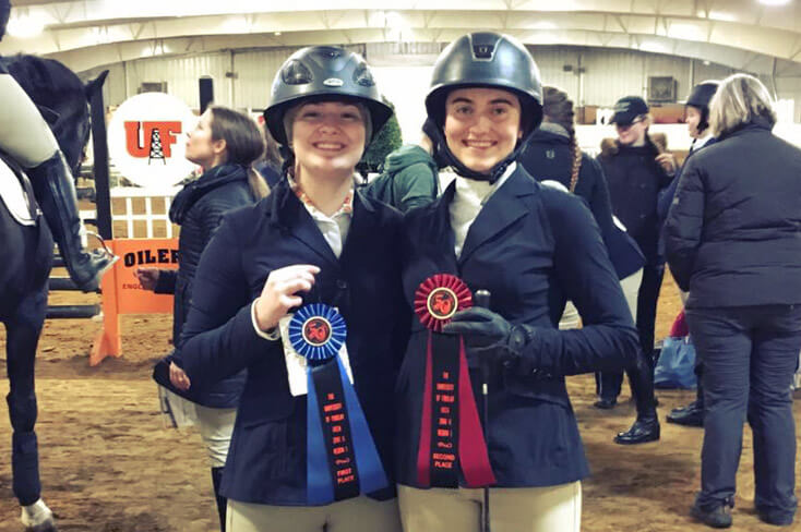 two english IHSA riders posing with first and second place ribbons