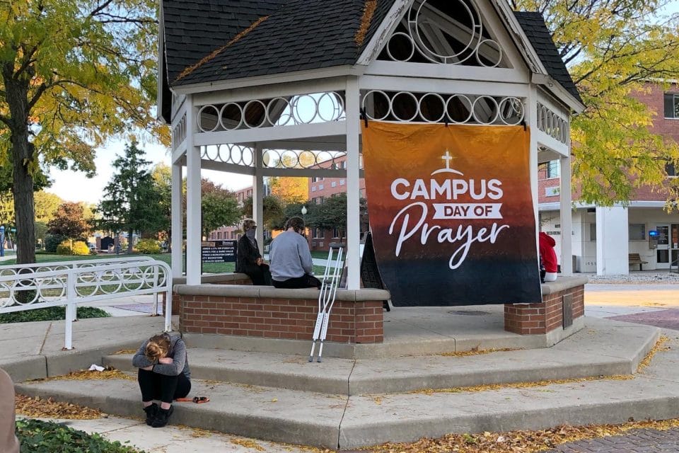 Dr. Fell sits in the gazebo with students for a moment of prayer