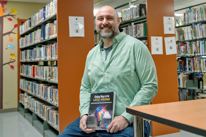 UF professor Kyle Wagner poses with a copy of his newly penned textbook.