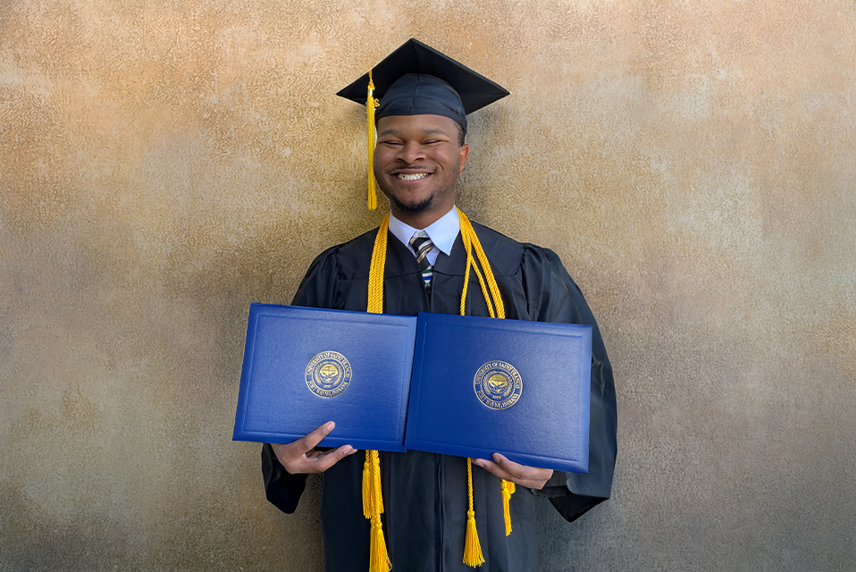 UF student, Keshon Thomas, smiles in graduation cap and gown.